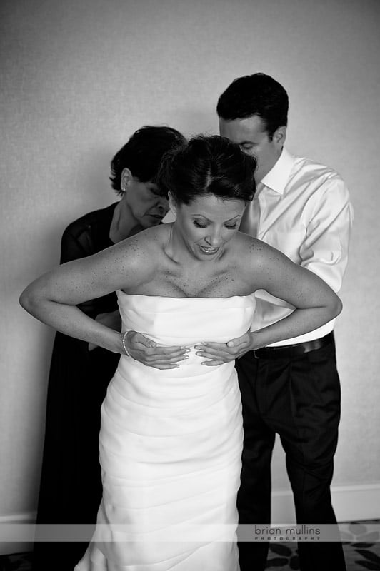 bride putting on wedding gown