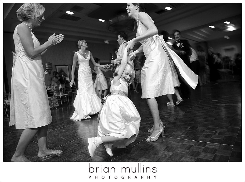 Little girl dancing with bridesmaid at wedding reception