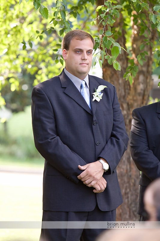 groom watching bride walk down the aisle