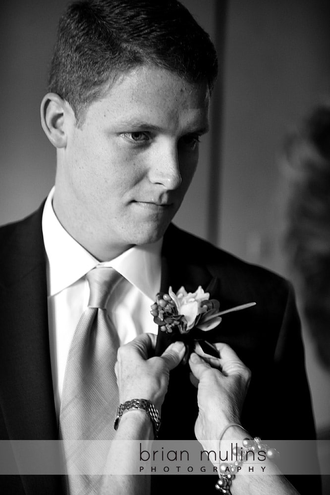 groom getting boutonniere pinned - Raleigh NC wedding photographer