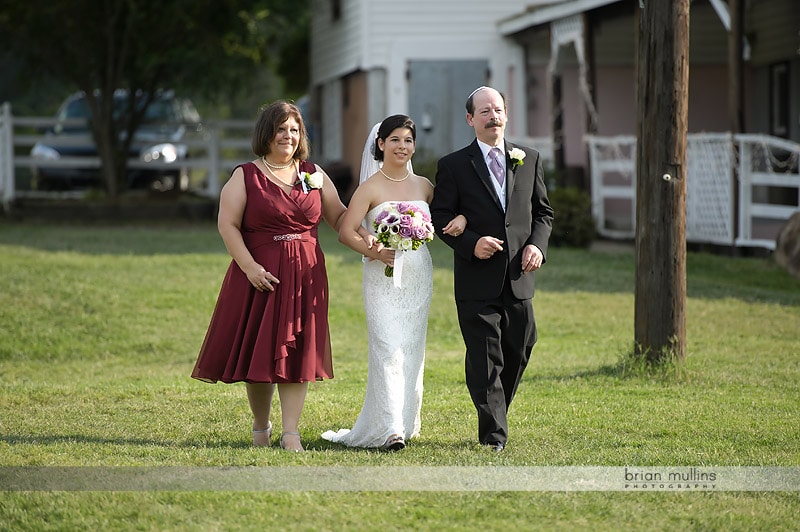 mom and dad walking bride down aisle