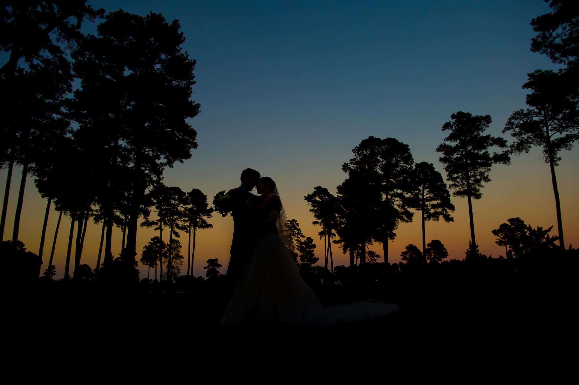 a sunset silhouette wedding photograph taken at the preston wood country club outside of Raleigh