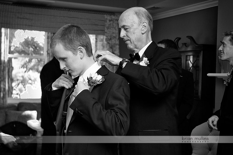 grooms father helping son get ready