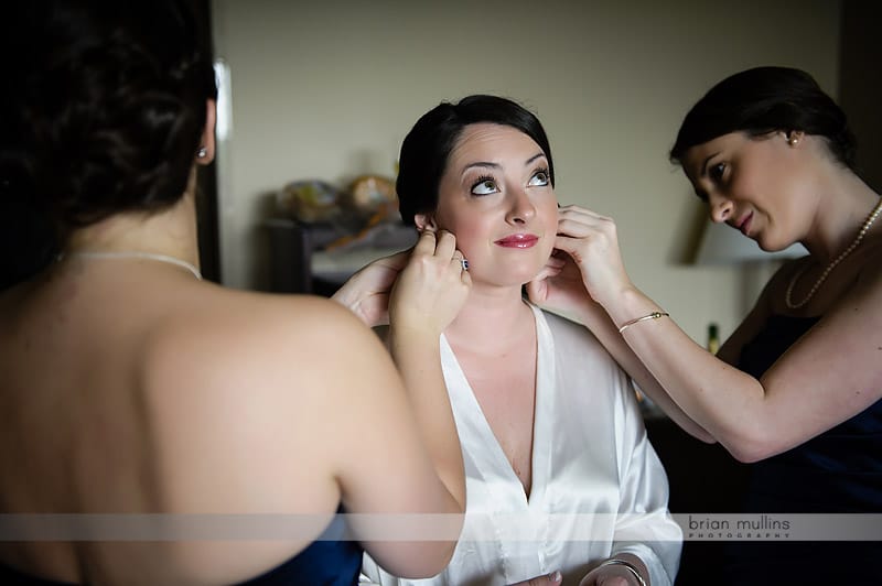 bride getting earrings put on