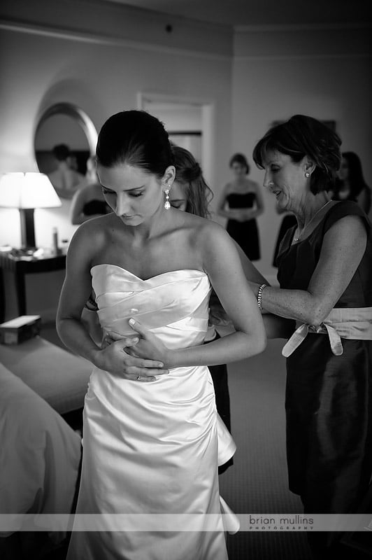 bride putting on wedding gown