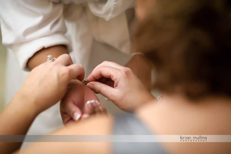 bride putting on wedding day jewelry