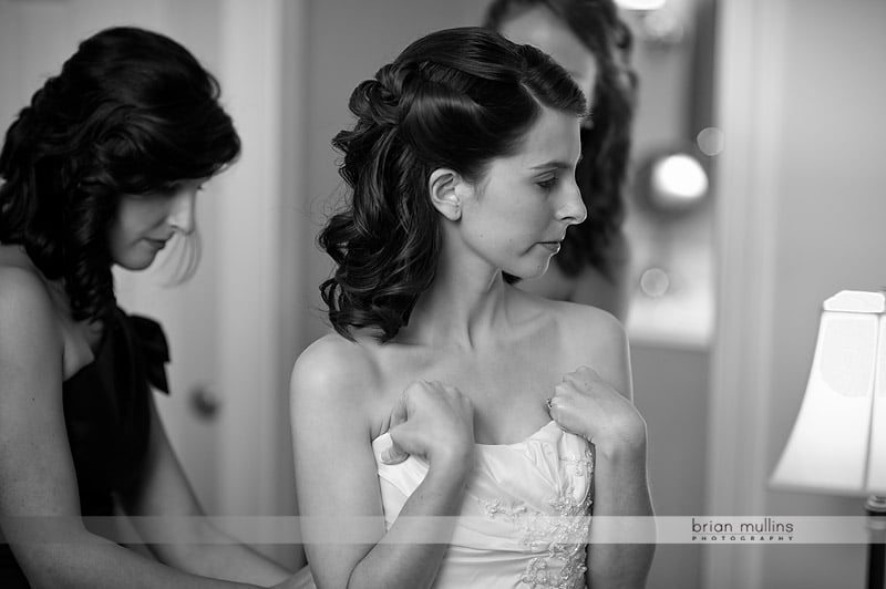 bride putting on wedding dress