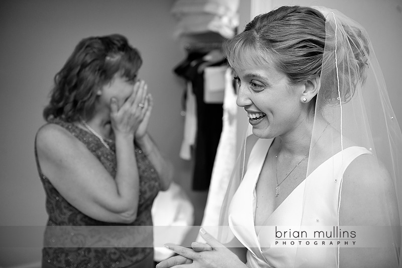 Mom crying after bride puts on dress