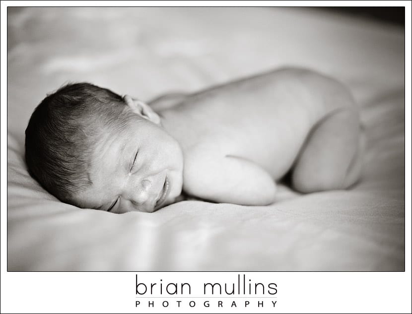 naked newborn on white blanket