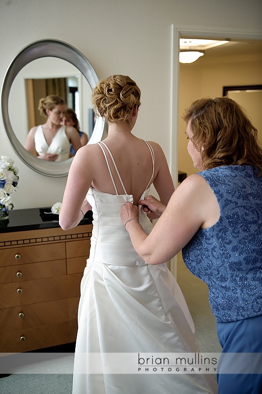 Bride putting on dress