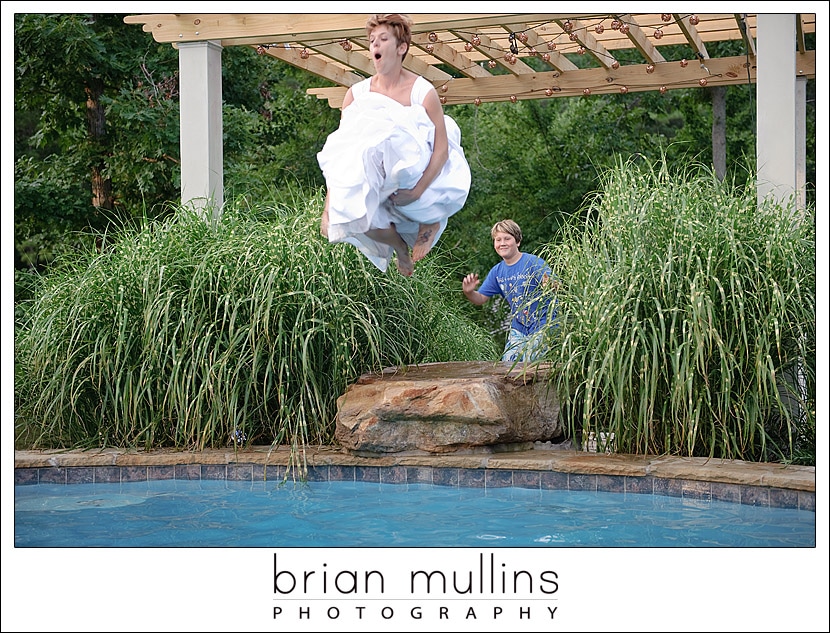 Bride in wedding dress jumping into the pool