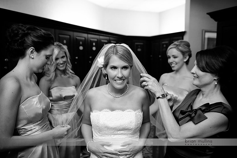 bride surrounded by bridesmaids while getting ready