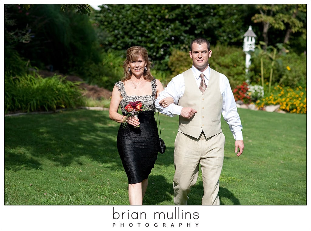 Groom walking his mom down the aisle on the wedding day