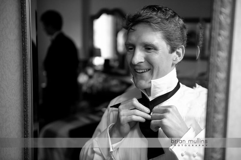 groom tying bowtie