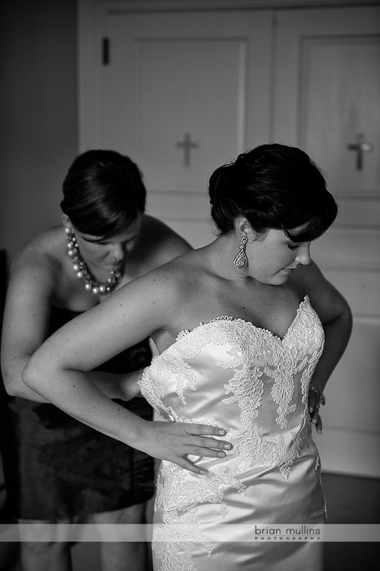 bride putting on wedding dress