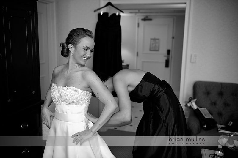 bride putting on wedding gown